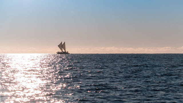 a waka at sea on horizon