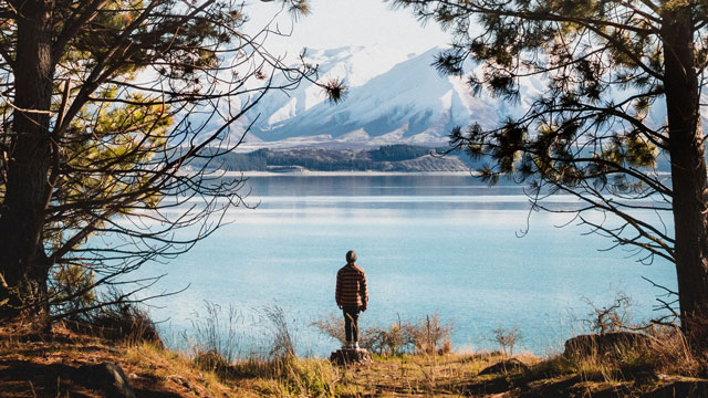 person alone looking out to lake and mountains