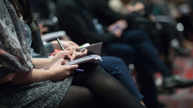 Seated people taking notes