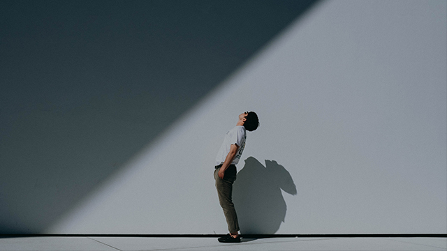 person standing in front of wall and leaning back