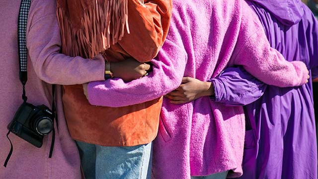 Four people with their arms around each other