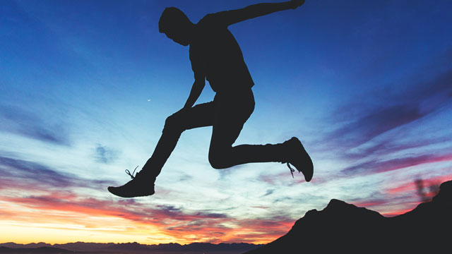 person leaping at dusk