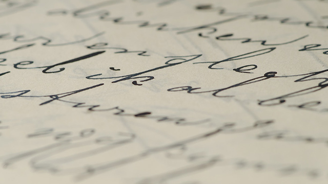 A close-up photograph of cursive handwriting. No legible text. 
