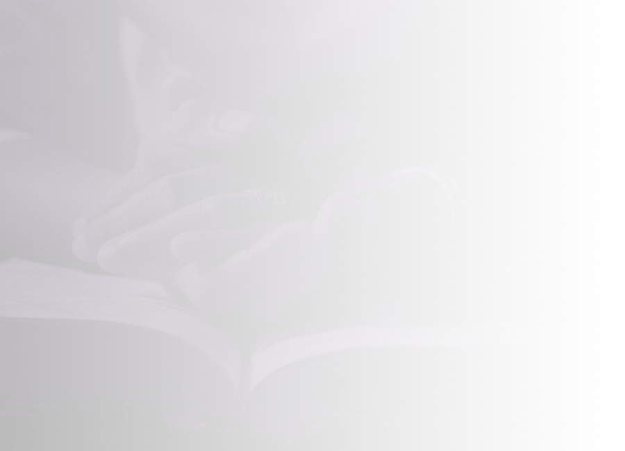 Clasped hands resting on an open book