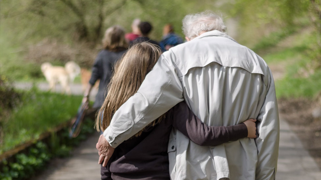 Grandparent and grandchild walking with an arm around each other