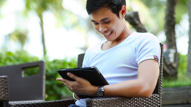 A man smiling while using a smart device