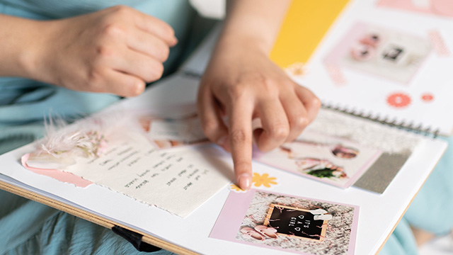 person pointing at picture in scrapbook