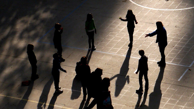 A group of young people standing in a circle playing tākaro-ā-ringa