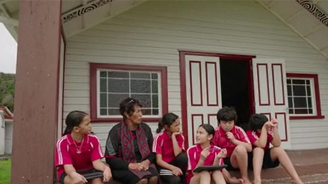 people sitting outside marae