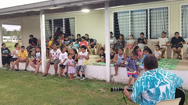 children sitting outside a building