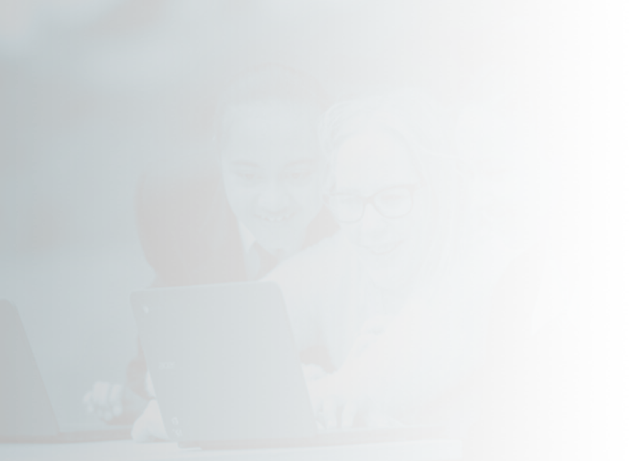 two students and a teacher looking at a laptop